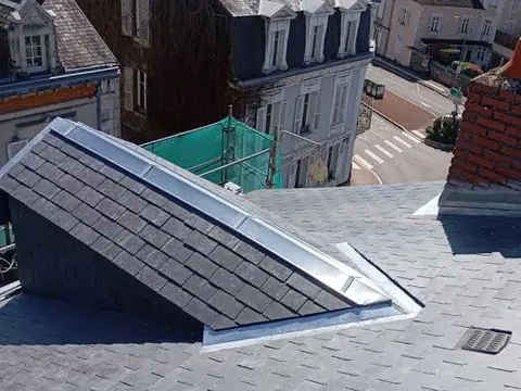 Détail de zinguerie et solin autour d’une fenêtre de toit sur couverture tuiles